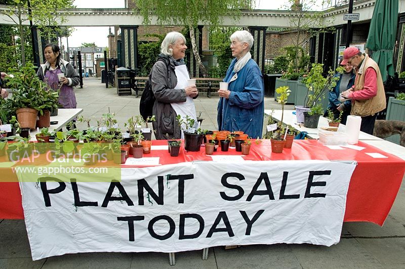 Bannière disant vente de plantes aujourd'hui avec deux femmes parlant derrière l'étal, Highbury Barn, London Borough of Islington, Royaume-Uni