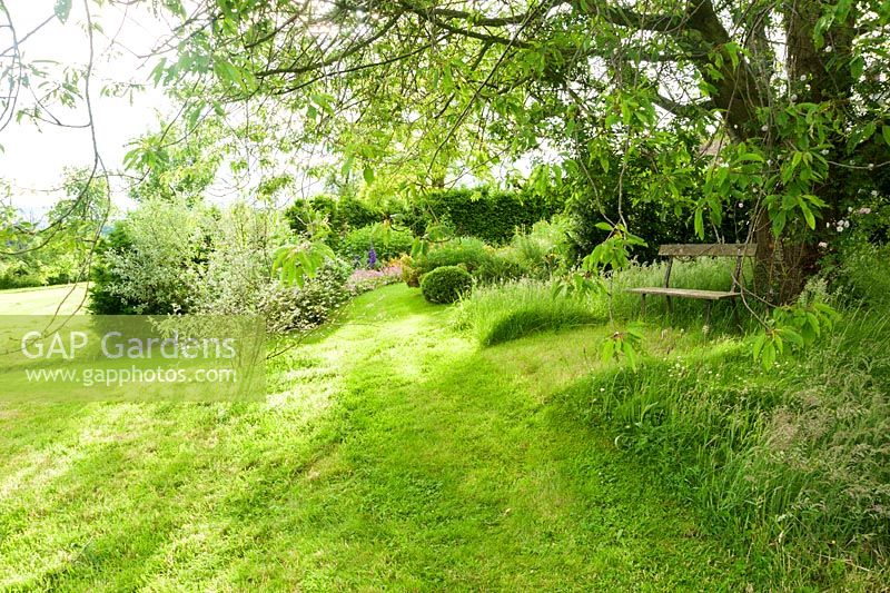 Les parties formelles du jardin s'ouvrent sur de vastes zones herbeuses. Ashley Farm, Stansbatch, Herefordshire, Royaume-Uni