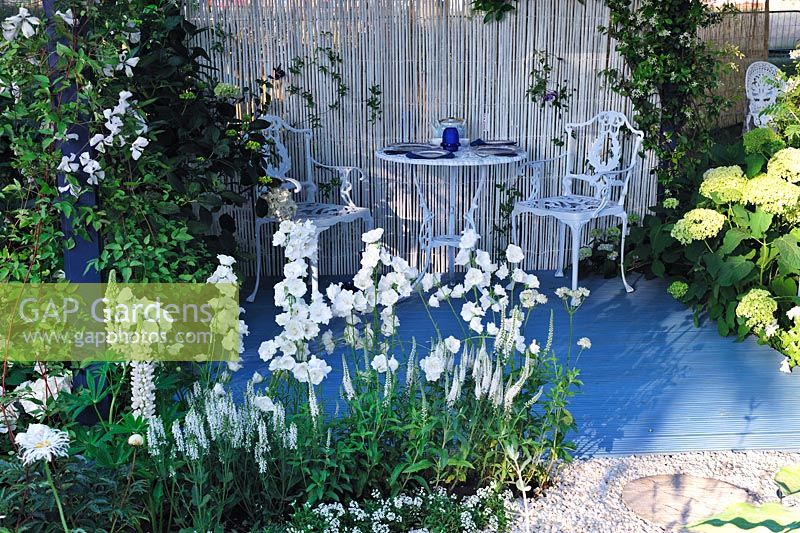 Chaises et table en métal. Campanule et lupins en parterre de fleurs blanches, Willow Pattern garden, Hampton Court Flower Show 2013, Design - Sue Thomas