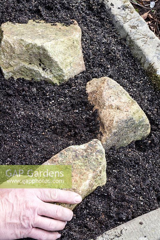 Planter un évier en pierre alpine - placer des roches dans une formation de strates