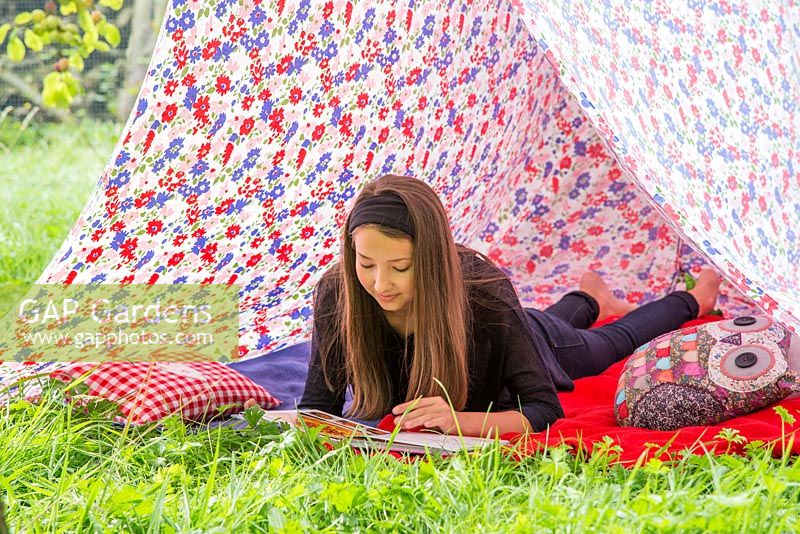 Jeune fille lisant un livre à l'intérieur d'une tente