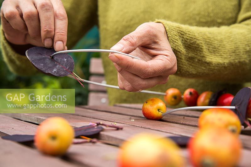 Enfiler des feuilles de Cotinus sur du fil d'armature en aluminium