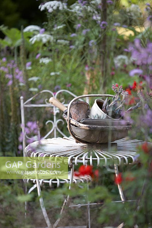 Table et chaise de jardin en métal avec trug en bois. 'The Hot Stuff Garden '. RHS Hampton Court Flower Show 2013.