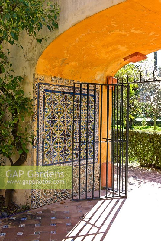 Arc d'entrée et passerelle avec décoration de carreaux Azulejos aux jardins du Real Alcazar, Séville, Andalousie, Espagne