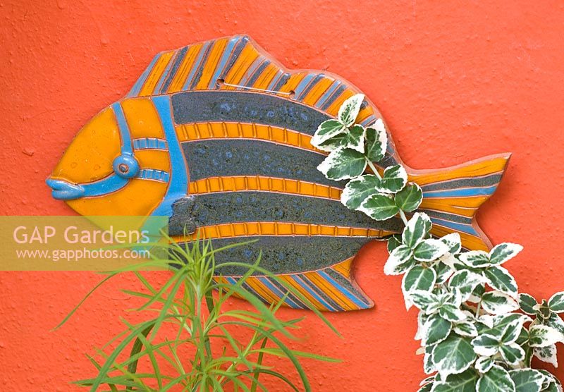 Mur orange avec poisson en céramique - le propriétaire a acheté cet ornement dans les Caraïbes