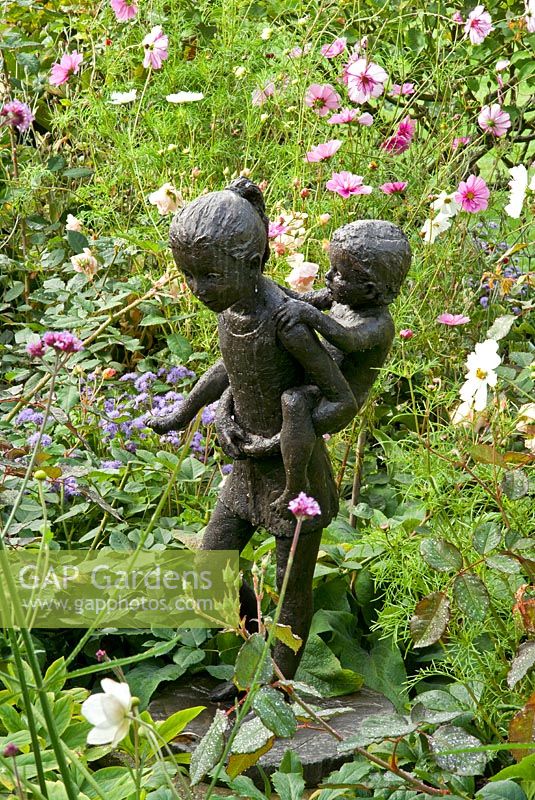Sculpture 'Piggy Back' de Mary Cox en parterre de fleurs mixtes. Début septembre.