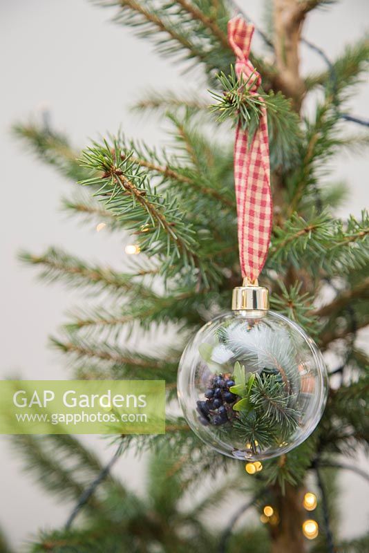 Boules naturelles sur un arbre de Noël. Fabriqué avec des boules vides, du ruban, des cônes cueillis, du feuillage et des baies