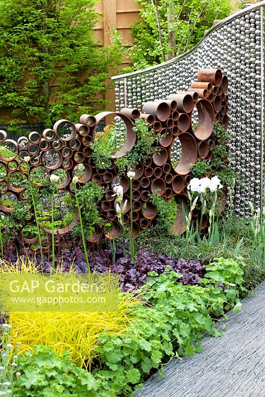 Le jardin SeeAbility, parterre de fleurs vivaces à base de feuillage avec sculpture en cercle en acier corten et structure à billes en acier inoxydable