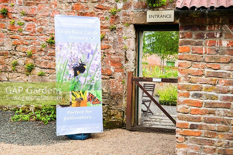 Entrée de la pépinière dans le jardin clos avec bannière du parc national. Pépinière du château de Chipchase, Wark, Northumberland, Royaume-Uni