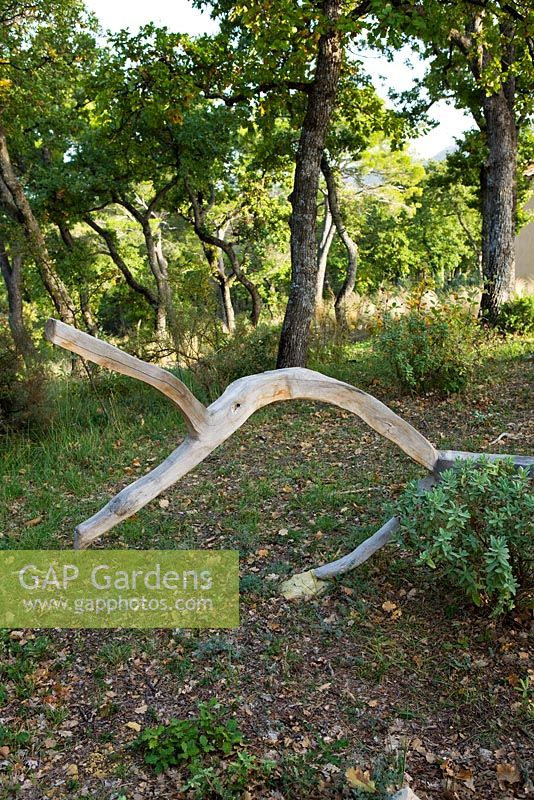 Sculpture en bois parmi les arbres par Marc Nucera. Provence, France, Domaine de la Verriere