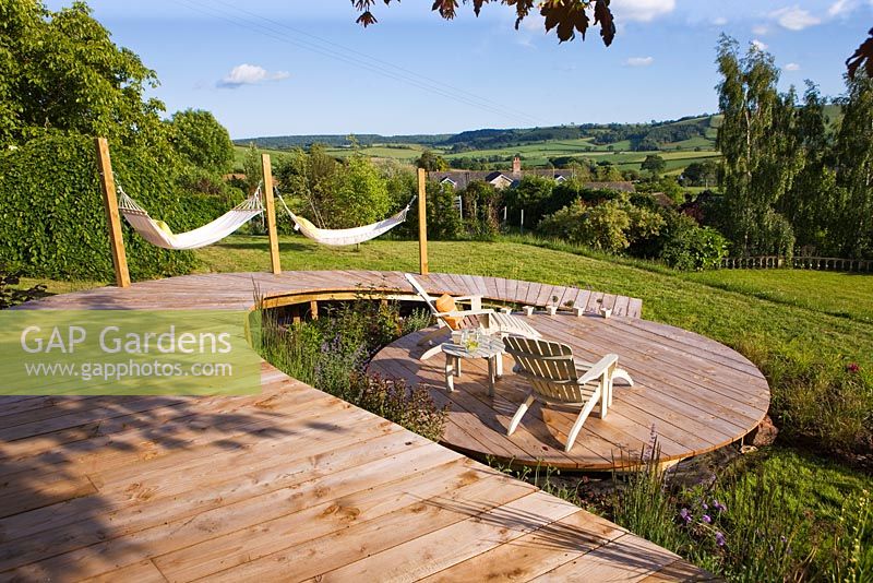 Construction d'une terrasse en bois circulaire - terrasse en bois circulaire avec passerelle, chaises de terrasse en bois et hamacs