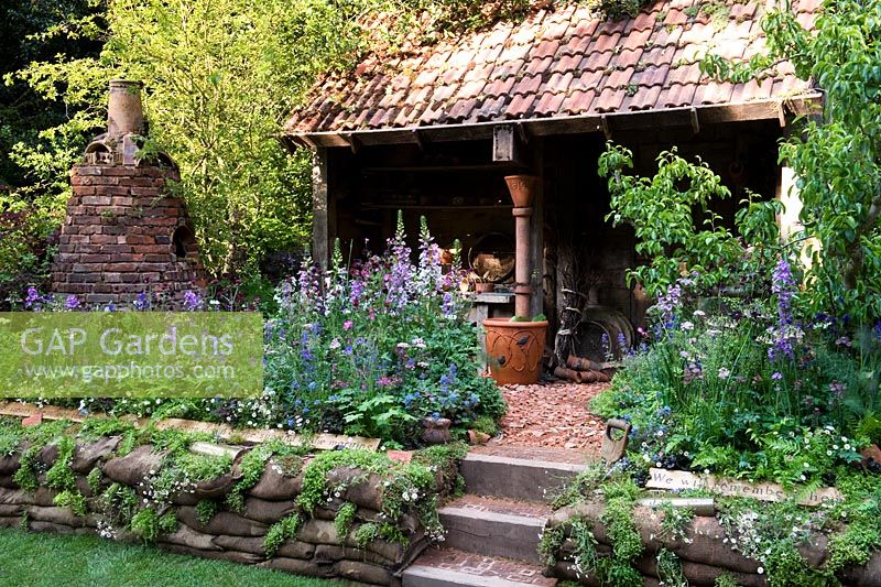 DialAFlight Potter's Garden - Atelier Bothy avec marches et parterre de style cottage.