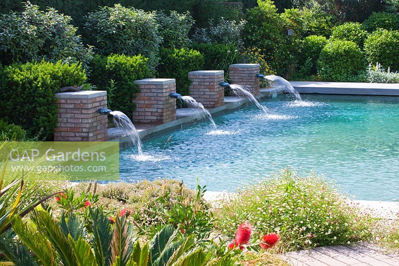 Jardin moderne et contemporain - piscine avec quatre jets d'eau en brique. Les Confines, Provence, France