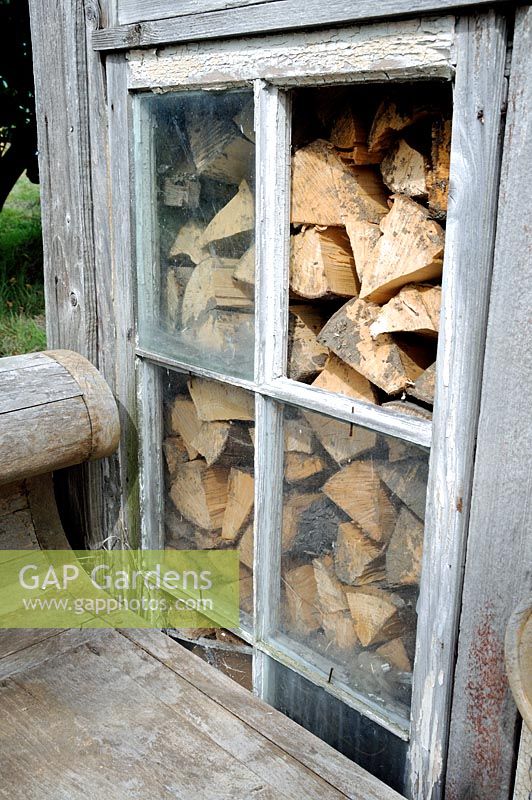 Bûches de bois vu à travers la fenêtre du hangar ou de la cabane d'attribution, allotissements de parcours de golf, London Borough of Haringey