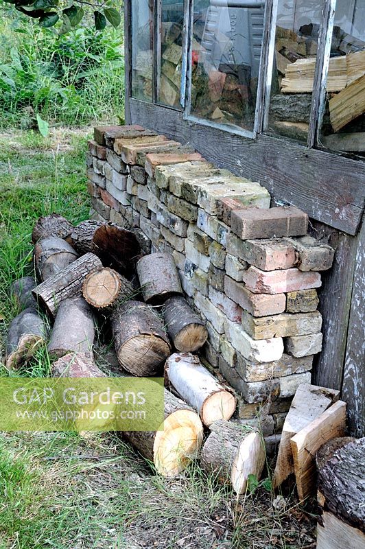 Bûches de bois avec des briques empilées à côté du hangar d'attribution, allotissements de parcours de golf, London Borough of Haringey