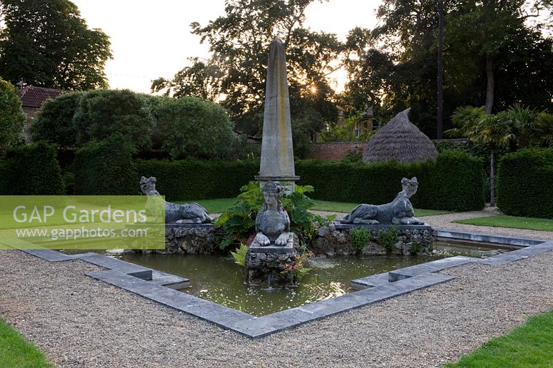 Obélisque en pierre avec des créatures mythiques symétriques à chaque coin situé dans un grand étang ornemental représentant l'Afrique. Seend, Wiltshire