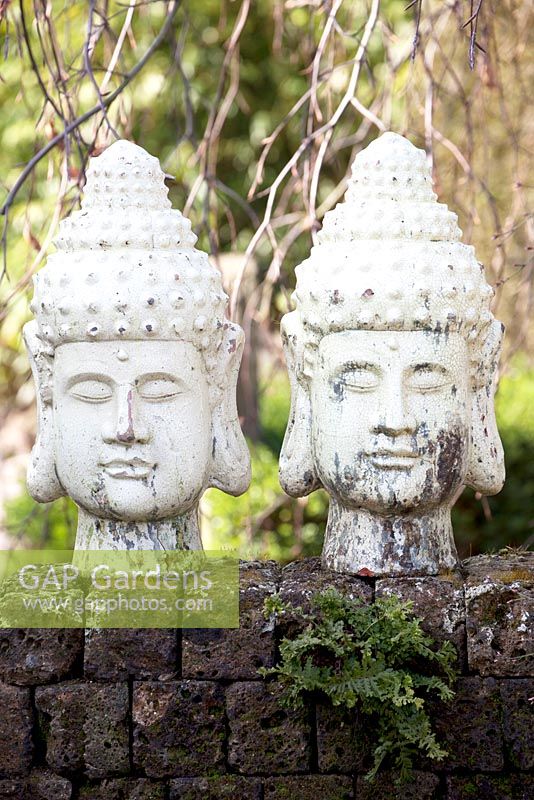 Deux têtes décoratives orientales sur un mur de briques. Jardins d'Appeltern, Hollande.