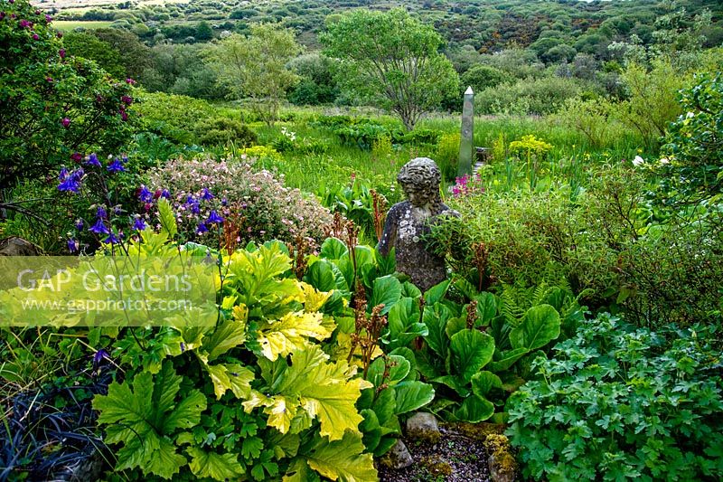 Sculpture de figure et vue sur le jardin de la tourbière, l'obélisque et les collines de Dinas. Dyffryn Fernant, Fishguard, Pembrokeshire, Pays de Galles du Sud