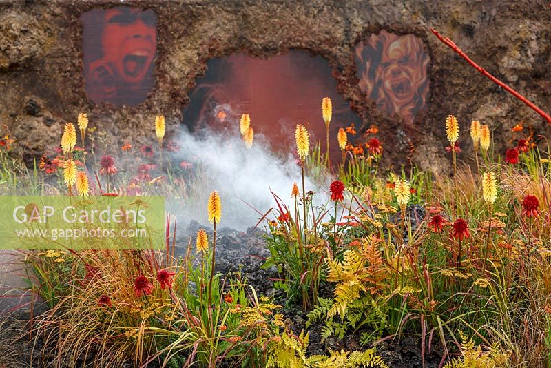 Plantation de couleur forte et chaude, y compris Kniphofia 'Tetbury Torch' avec de la fumée, de la lave et des cendres sur le thème du volcan, Éruption d'une colère non guérie, RHS Hampton Court Flower Show 2014
