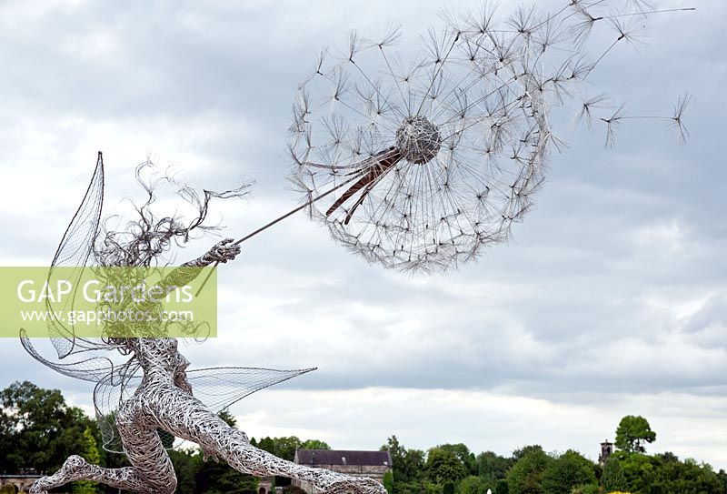 Sculpture en acier inoxydable de fée soufflant une horloge de pissenlit à Trentham Gardens, Staffordshire