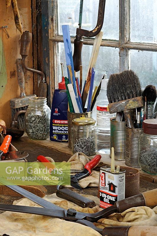 Outils de jardin, sécateur et cisaille sur banc d'atelier, prêts à être nettoyés et affûtés