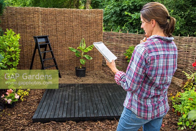 Examen du croquis du plan de jardin, avec les plantes et les accessoires en position