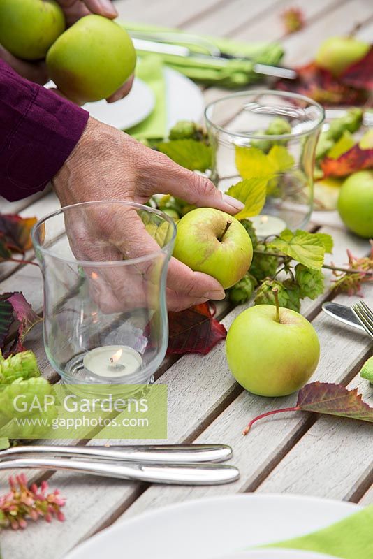 Table décorative créative pour femme à l'aide de houblon, de pommes et de feuillage d'Acer rufinerve