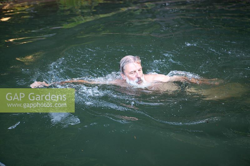 Homme nageant dans son étang de baignade naturel - Ian Mabberley