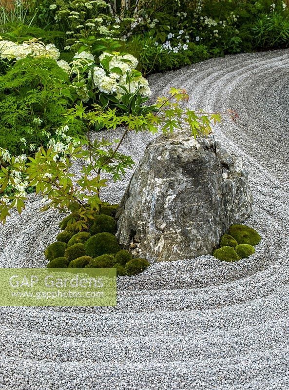 Un petit jardin de style japonais avec parterre de fleurs de l'île et gravier ratissé qui symbolise l'eau.