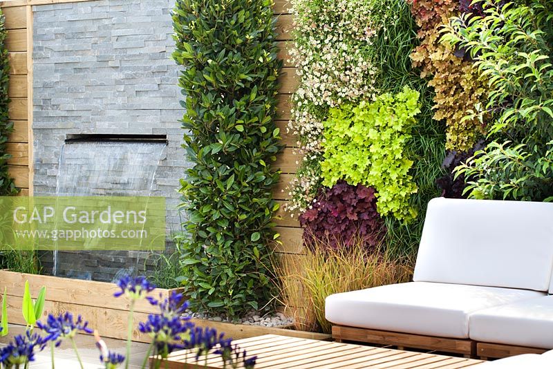 Chaises avec coussins sur terrasse en bois. RHS Hampton Court Flower Show 2014, conception: Ian Hammond