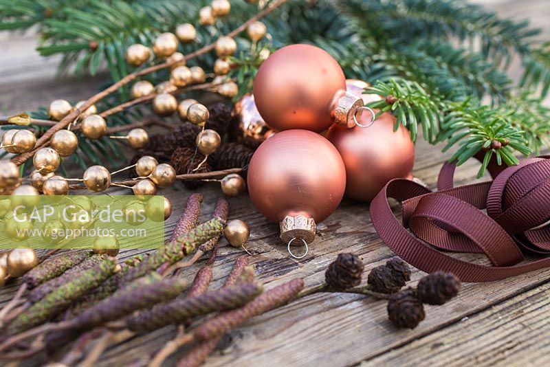 Décorations de Noël sur le thème de la couleur cuivre. Boules, ruban, feuillage d'aulne et feuillage d'if