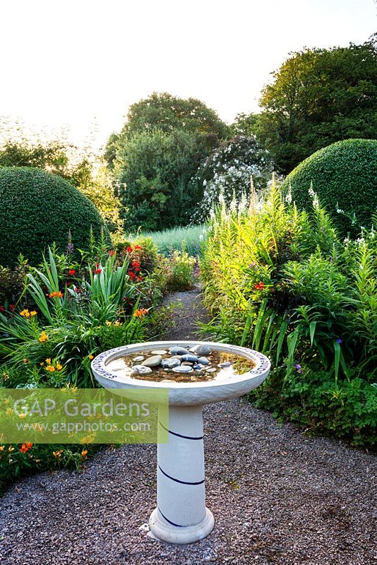 Bain d'oiseau dans le jardin avant. Veddw House Garden, Devauden, Monmouthshire, Pays de Galles. juillet