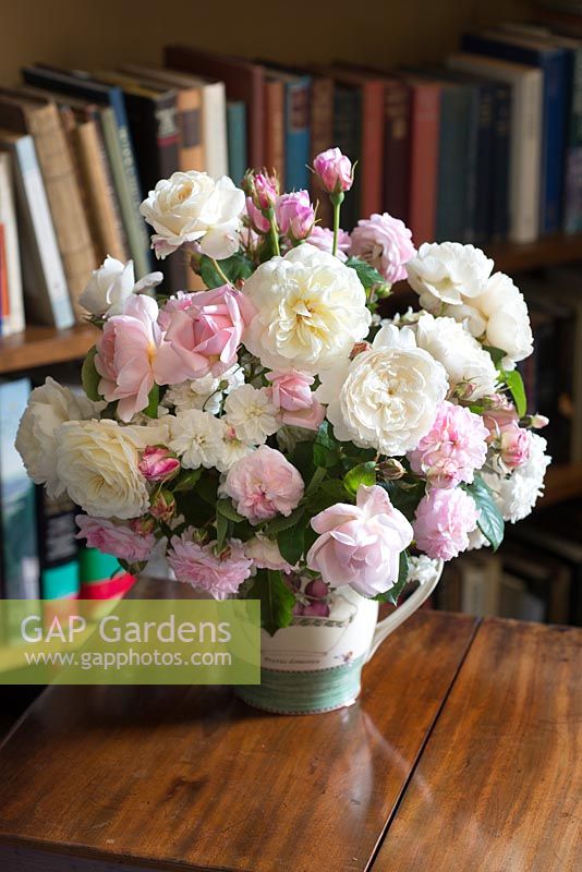 Arrangement de fleurs coupées avec crème et roses roses sur une table à l'intérieur