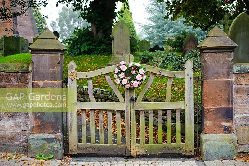 Roses roses dans un arrangement circulaire en deux parties sur la porte de l'église lych pour un mariage. Rose 'Keira' une variété de fleurs coupées de David Austin Roses