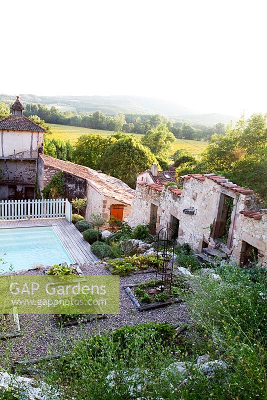La piscine et les parterres de fraises à Grange Rousseau, Tarn, France. Contexte des collines environnantes et des ruines antiques.