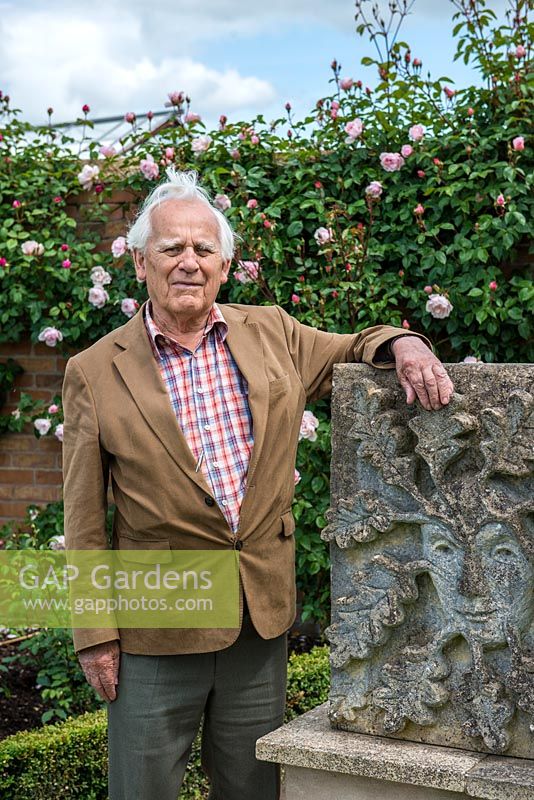 Portrait de M. David Austin OBE VMH, à côté d'une sculpture de l'homme vert, par sa défunte épouse, Mme Pat Austin, un sculpteur de talent.
