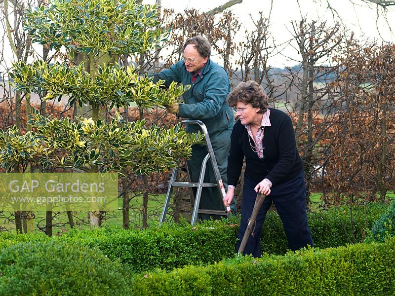 Simon et Kathy Brown travaillant dans le jardin à la française avec son parterre en boîte coupé, son topiaire en if et ses étages de houx.