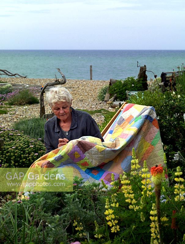 Liz Shackleton, artiste textile, travaille dans son jardin en bord de mer sur une courtepointe patchwork.