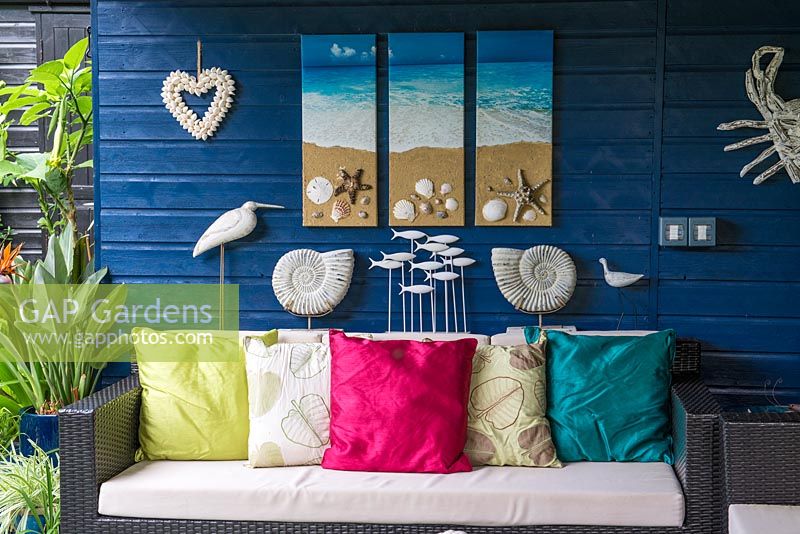 Un coin salon couvert avec des décorations inspirées de la mer et un canapé.