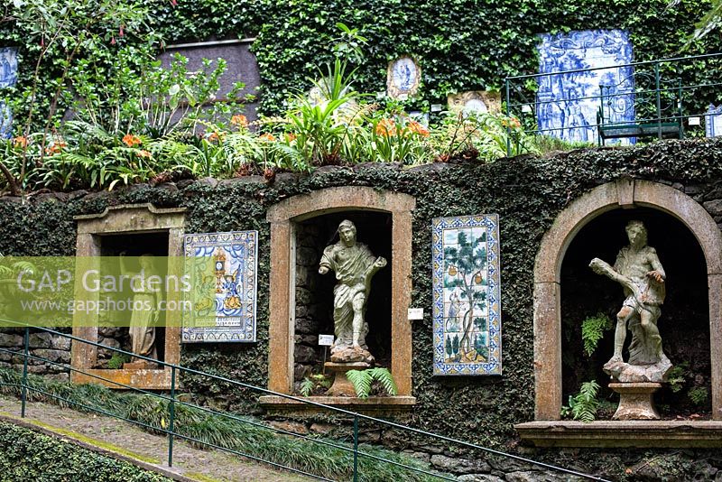 Panneaux carrelés, niches remplies de statues classiques, sculptés dans les murs du jardin tropical Monte Palace, Madère