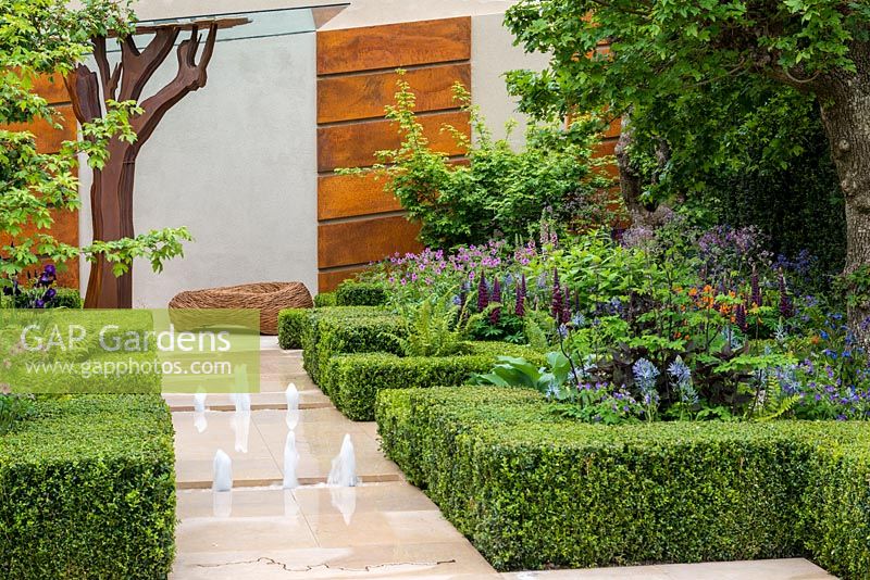Le jardin Morgan Stanley Healthy Cities. Une structure formelle de haies de buis et de chemins de pierre contraste avec une tapisserie de vivaces.