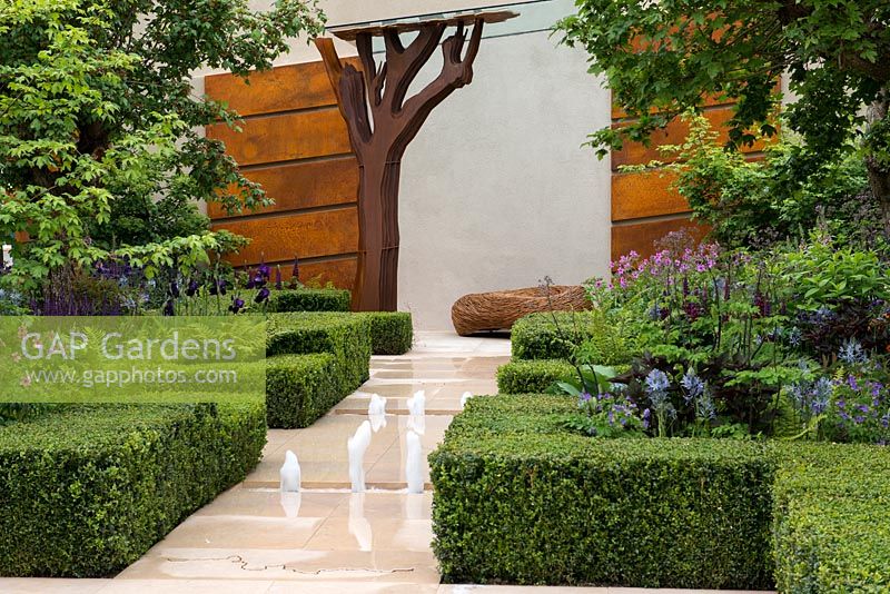 Le jardin Morgan Stanley Healthy Cities. Une structure formelle de haies de buis et de chemins de pierre contraste avec une tapisserie de vivaces