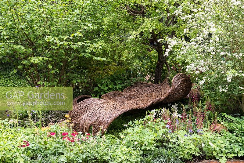 Siège en saule tissé dans une clairière boisée tranquille. Jardin du cancer du sein Haven. RHS Chelsea Flower Show, 2015