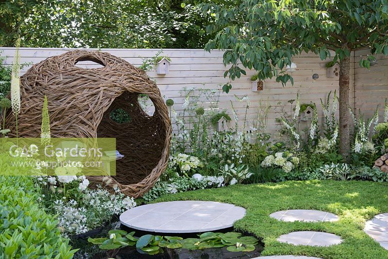 Peau d'oiseau en saule tissé sphérique avec banc, parterres de fleurs blanches avec clôture, pavage circulaire, pelouse de camomille et étang avec Nymphaea - Paysages vivants: City Twitchers Garden, RHS Hampton Court Palace Flower Show 2015