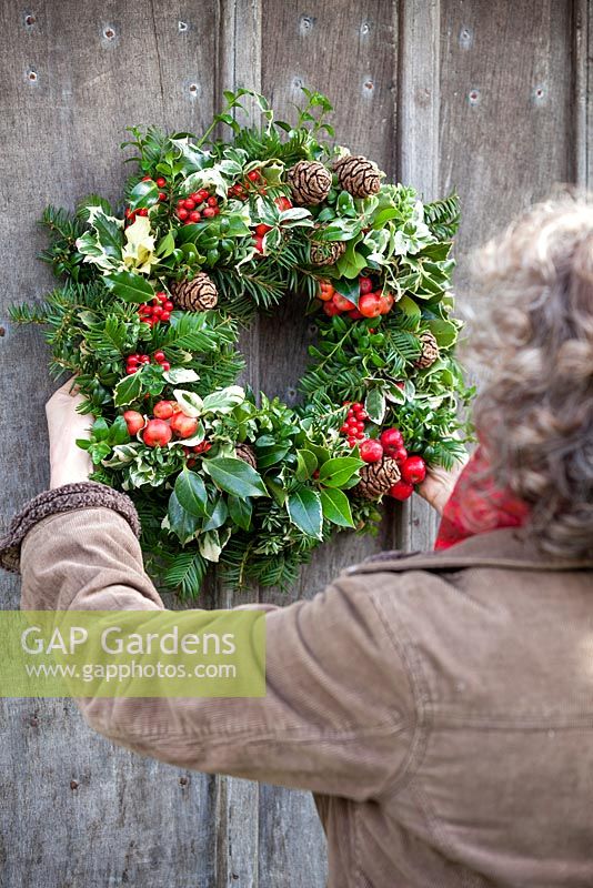 Gabbi Reid accroche une couronne de Noël terminée sur une porte. Gabbi's Garden, décembre.