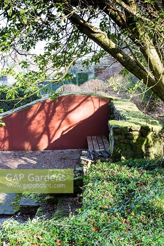 La ruine. Ombres d'arbres sur mur de forme d'onde peinte. Veddw House Garden, Monmouthshire, Pays de Galles du Sud. Mars 2015. Jardin conçu et créé par Charles Hawes et Anne Wareham