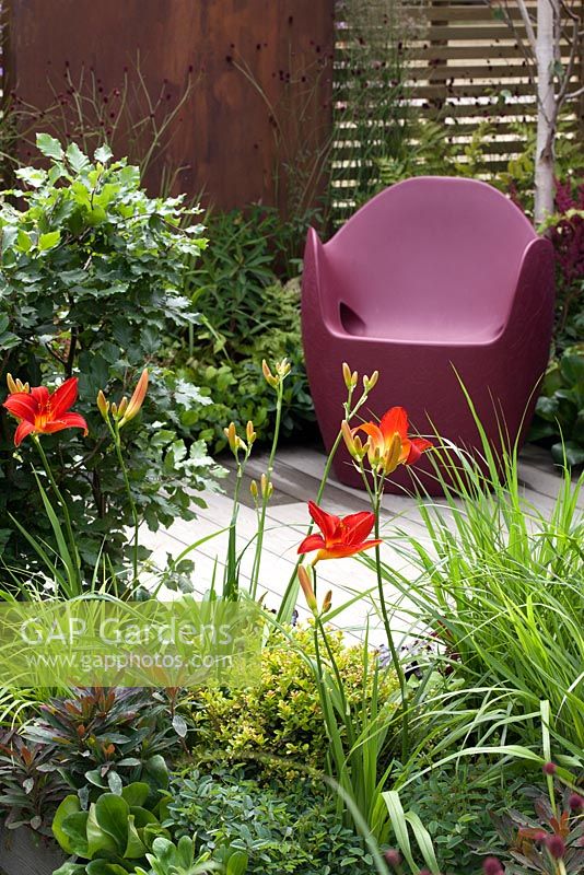 Siège en plastique moulé entouré de plantes chaudes et panneaux métalliques - Fondations pour Growth Garden au RHS Hampton Court Palace Flower Show 2015