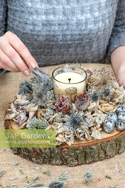 Création d'une décoration de table festive avec des fleurs de jardin et des têtes de graines. Terminez avec une pincée de paillettes argentées.