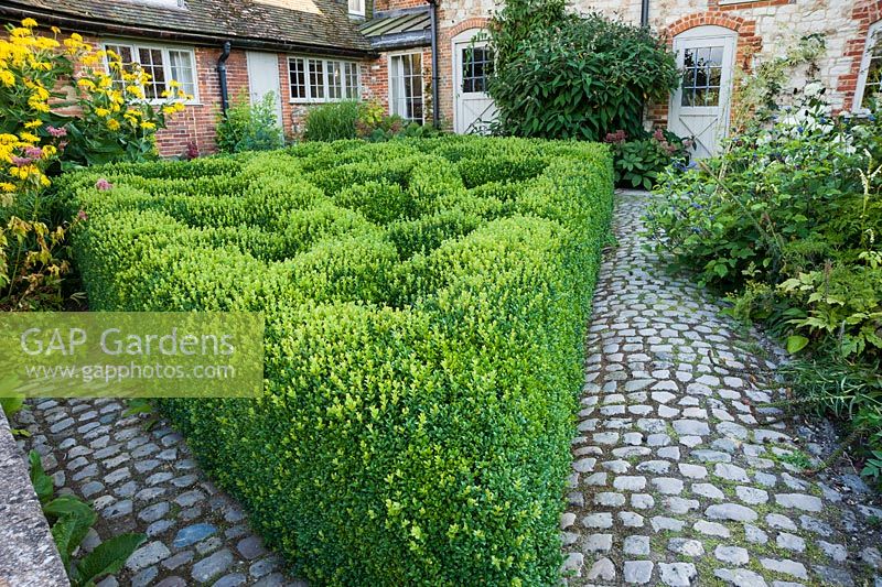 Le Courtyard Garden conçu par Piet Oudolf et John Coke présente un motif en treillis de boîte clippée dans un coin. Bury Court Barn, Bentley, Hants, Royaume-Uni