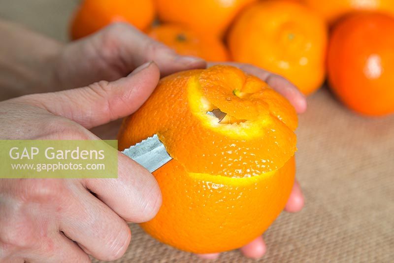 Reposez l'orange dans votre main de rechange et pelez doucement avec une spirale descendante